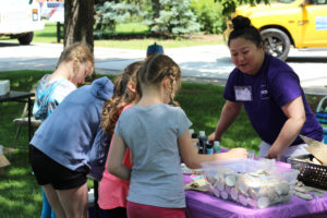 ACT MCRC artist at Fun Fair helping Children paint