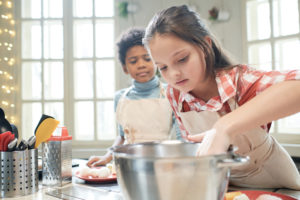 Girl preparing the dough for cake